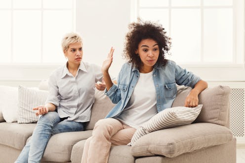 Two female friends sitting on sofa and arguing with each other. Friendship, quarrel, female disagree...