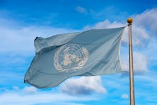 Waving united nations UN flag in the deep blue sky background