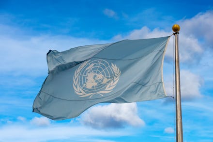 Waving united nations UN flag in the deep blue sky background