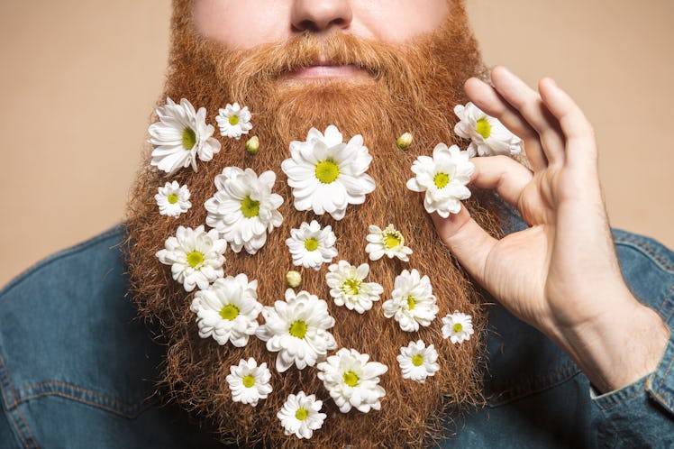man who grew a beard decorates his facial hair with flowers