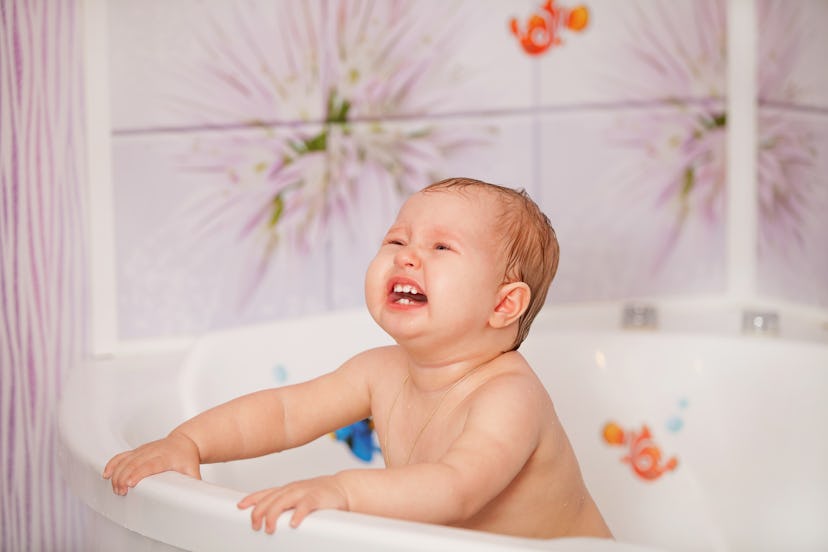 Crying baby swims in the bathtub