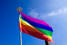 Rainbow flag on blue sky background.LGBT flag ,gay flag,gay pride.Gay flag Uk.Gay flag covering vert...