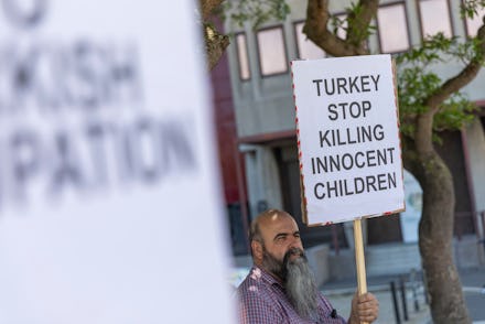 Members of the Kurdish Human Rights Action group protest outside the South African Parliament in Cap...