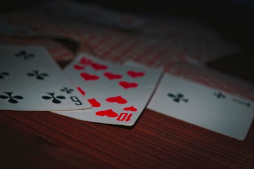 Old playing cards on wooden background close-up