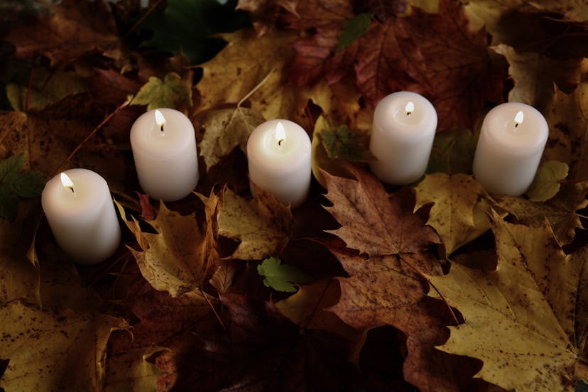 burning candles candles standing among yellow autumn foliage