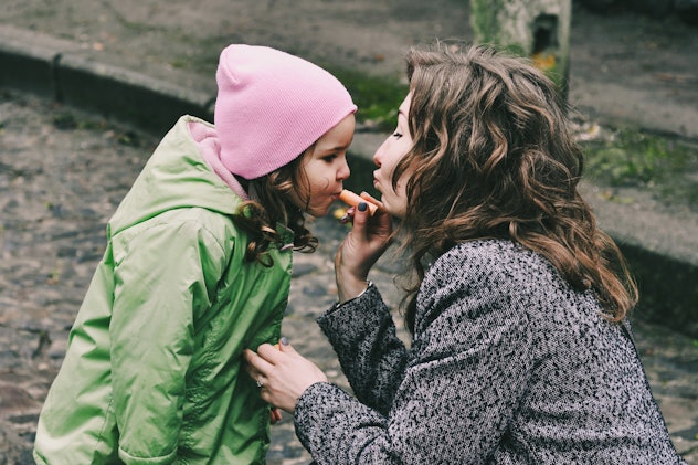Mother and daughter. Mama put lip balm on daughters lips. Happy family. Amazing, laughing women. Hap...