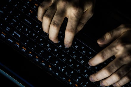 Back View of Teenage Hacker Working in Computer and Infecting with Virus Data Servers of Government ...