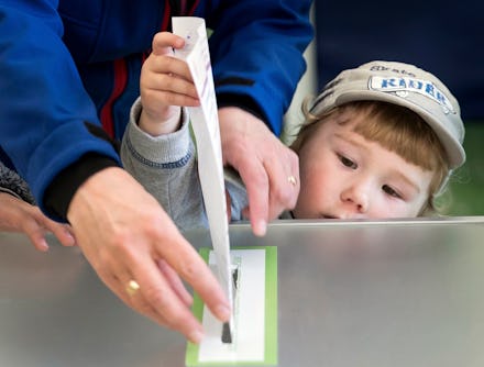 A woman and child cast her ballot during the first round of voting in presidential elections in Viln...