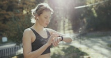 Sport Woman Running In City Park Wearing Smartwatch And Wireless Earphones