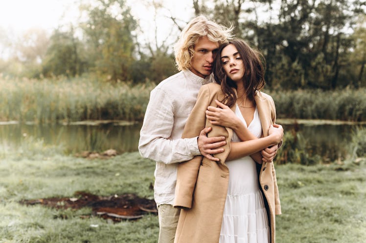 beautiful couple dressed in boho style walking in the sunny forest