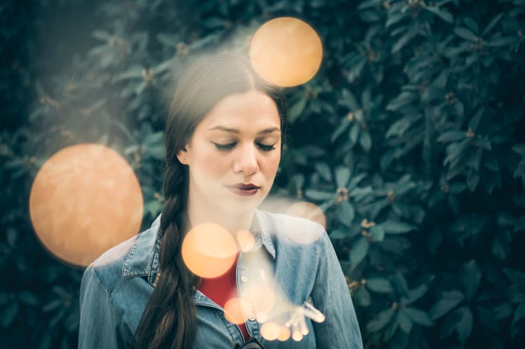 Moody and emotional portrait of a beautiful young woman, urban style, with fairy lights - Emotion, t...
