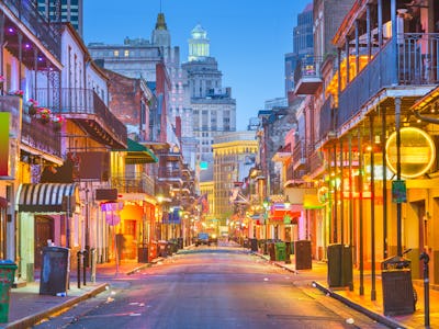 Bourbon St, New Orleans, Louisiana, USA cityscape of bars and restaurants at twilight.