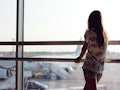 A young woman looks out at planes from an airport window. The chances of a plane crash are extremely...