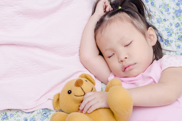 Little Asian girl sleeping on bed