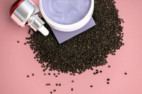 Babchi dry raw seeds (Psoralea Corylifolia) with bakuchiol skin care cream and oil in tube on pink s...