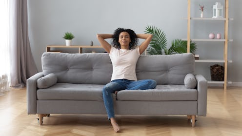 Woman on a couch meditating and practicing mindfulness.