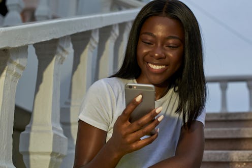 Nice black woman looking her smartphone