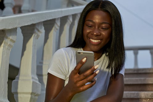 Nice black woman looking her smartphone            