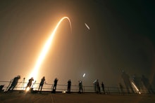 Photographers on the roof of the Vehicle Assembly building capture the launch and rocket boosters la...