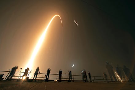 Photographers on the roof of the Vehicle Assembly building capture the launch and rocket boosters la...