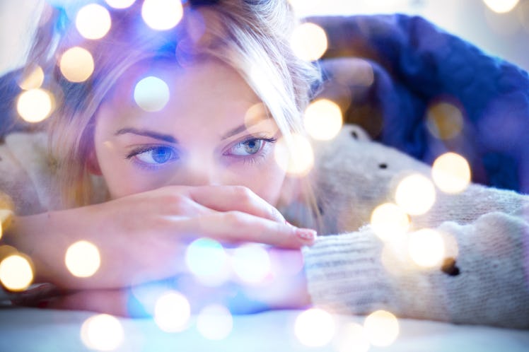 Lonely sad girl lying on bed in a bedroom , bokeh light balls illuminating the shot