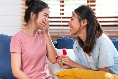 Happy asian couple lesbian proposal with ring for marry at living room at home.LGBTQ lifestyle conce...