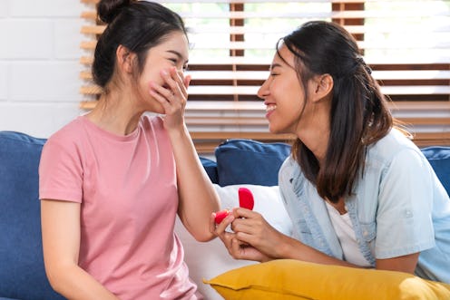 Happy asian couple lesbian proposal with ring for marry at living room at home.LGBTQ lifestyle conce...