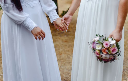 Same sex gay couple having their wedding, wearing dresses.