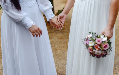 Same sex gay couple having their wedding, wearing dresses.