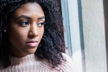 Woman sad staring out a window