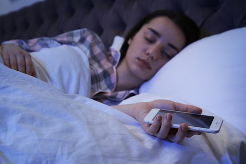 Lonely woman sleeping with smart phone in bed, closeup