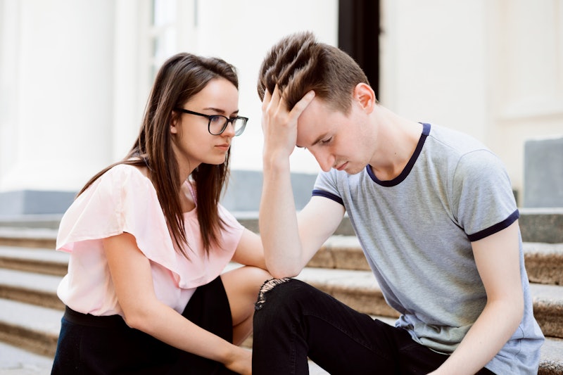 Female student calms her male friend. Teenager is upset, sits on stairs and don`t wont anything, his...