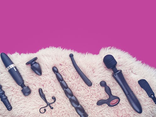 Sex toys (dildo, vibrator, anal plug and other) are on light sheep's fur. There is a fuchsia-colored...