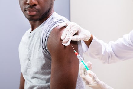Close-up Of Doctor Injecting Vaccine Into Patients Arm With Syringe