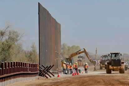 Government contractors erect a section of Pentagon-funded border wall along the Colorado River, in Y...