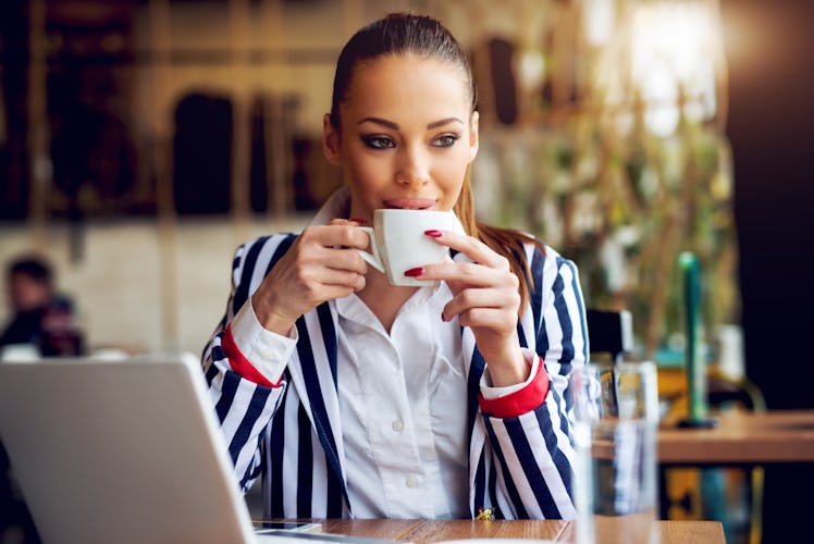 Young beautiful woman drinking coffee at cafe bar.