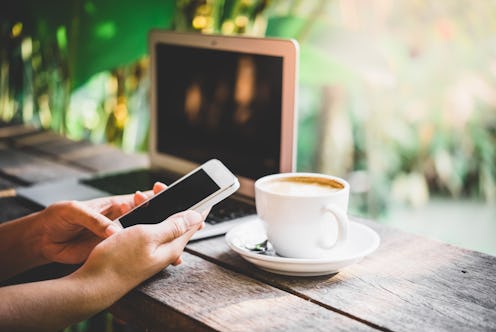 A woman uses her smartphone at a coffee shop.