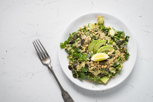 Fresh quinoa salad with spinach, avocado, seeds and Pine nuts at white. Clean eating detox and veget...