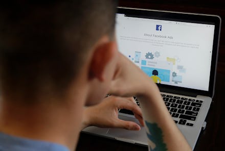 A man poses for photos in front of a computer showing a Facebook ad preferences page in San Francisc...