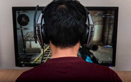 Gamer in headphone playing video game at home. 