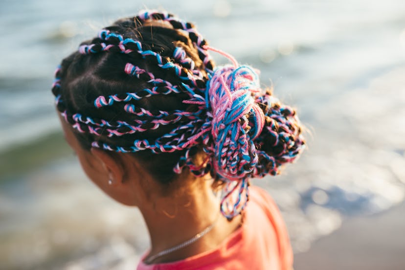 Handsome girl kid with bright colored afro braids. creative hairstyle