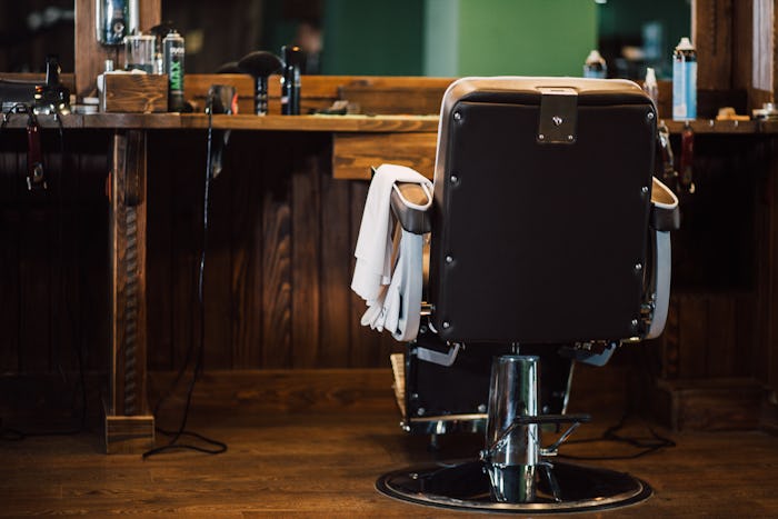 A barber chair sits in an empty barbershop.