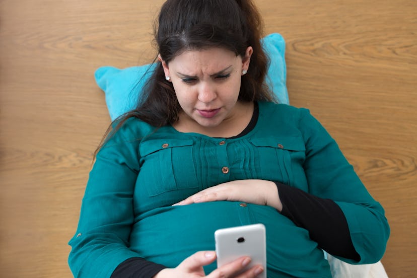 Pregnant woman in bed feeling a contraction
