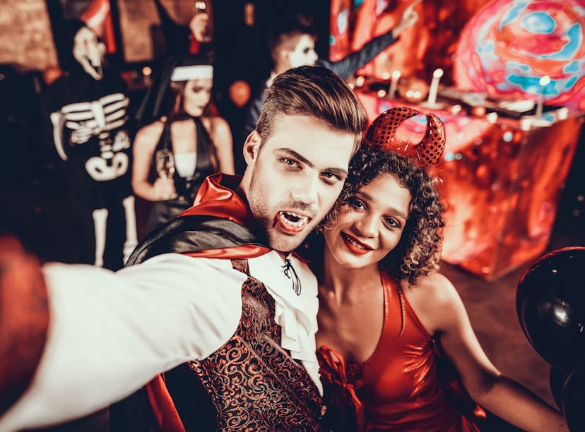 Young couple in Halloween costumes taking a selfie.