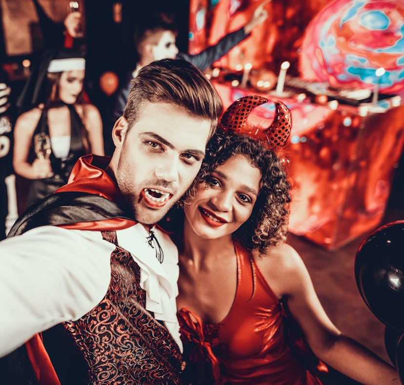 Young couple in Halloween costumes taking a selfie.