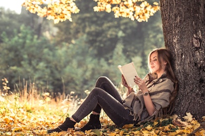 beautiful girl reading a book in autumn forest , autumn season concept and reading