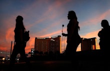 People carry flowers as they walk near the Mandalay Bay hotel and casino during a vigil for victims ...