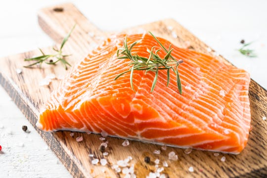 Salmon fish. Uncooked salmon fillet with lemon sea salt and rosemary on white. Close up.