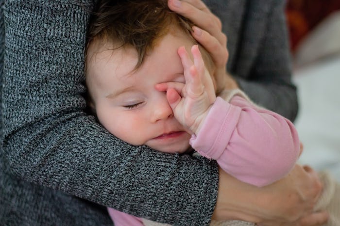 tired baby rubbing her eyes