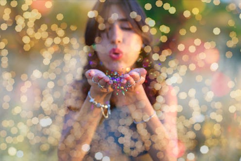 Young beautiful women blowing colorful confetti stars from hands. Celebration and event concept. Mom...
